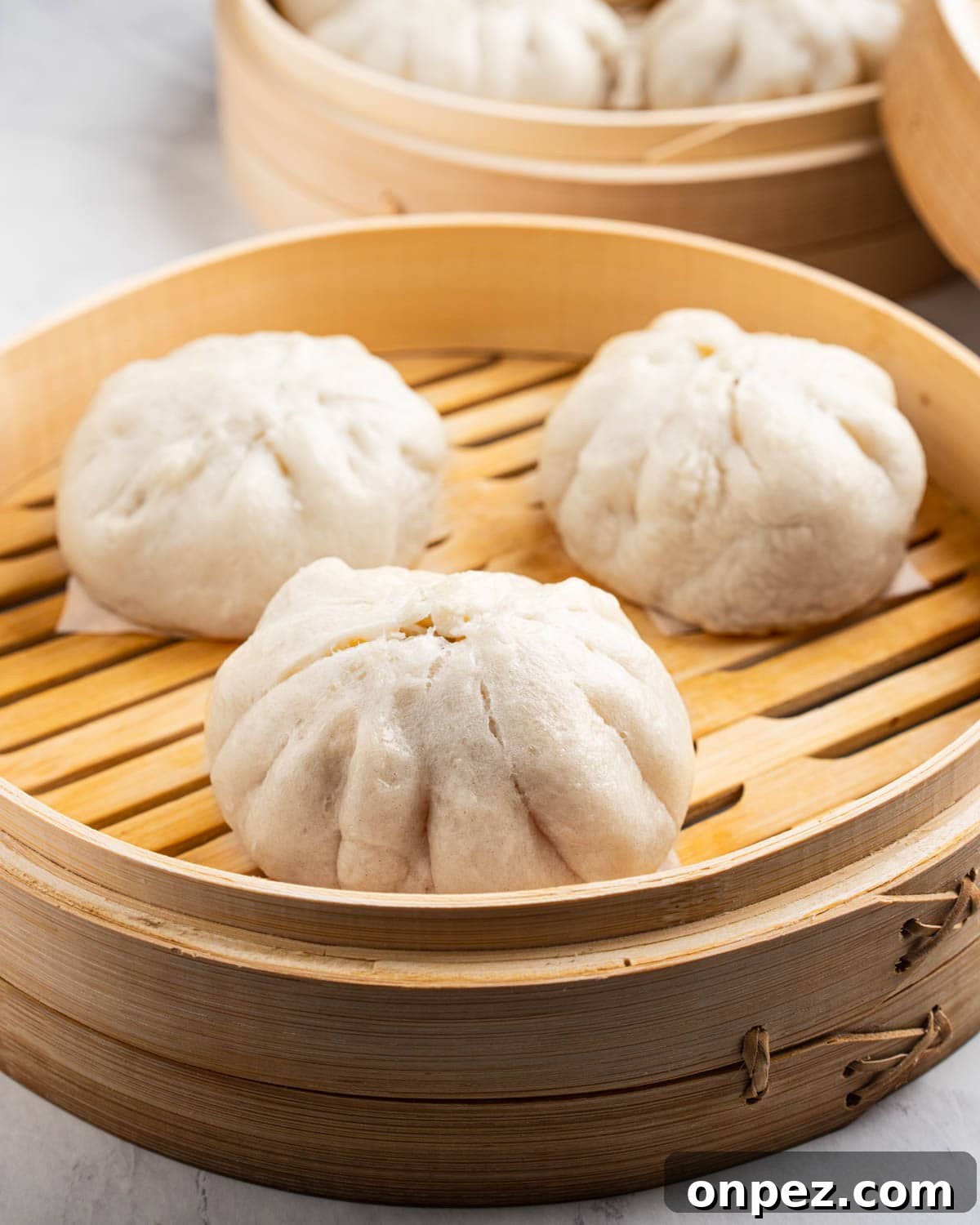 2 bamboo steamer baskets filled with Banh Bao.
