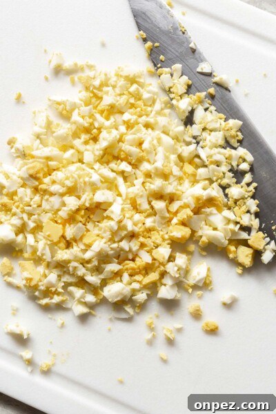Creamy Egg Salad Tea Sandwiches Recipe 5 Chopping eggs with a knife.