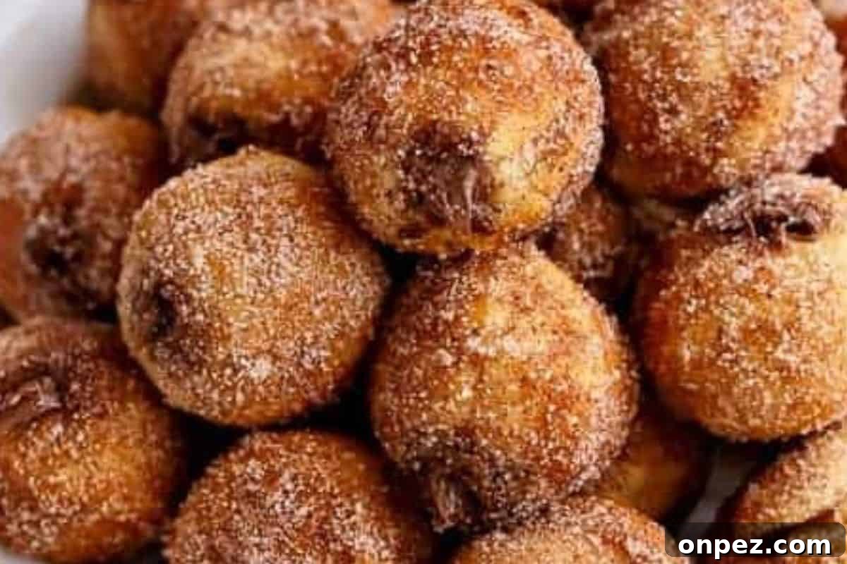 Spoon melted Nutella into a piping bag fitted with a narrow nozzle. and fill each donut.