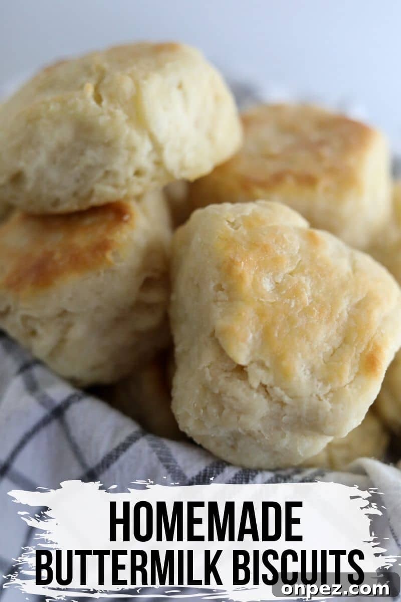 Flaky Homemade Buttermilk Biscuits from Scratch 2 biscuits piled on top of each other in a basket