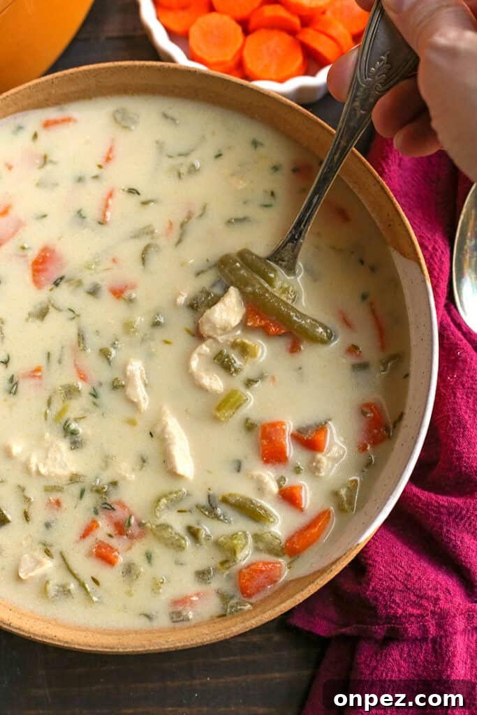 paleo creamy chicken soup with a soup taking a bite
