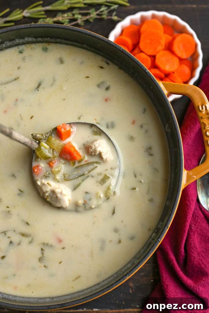 pot of paleo gluten free creamy chicken soup with a ladle taking a scoop