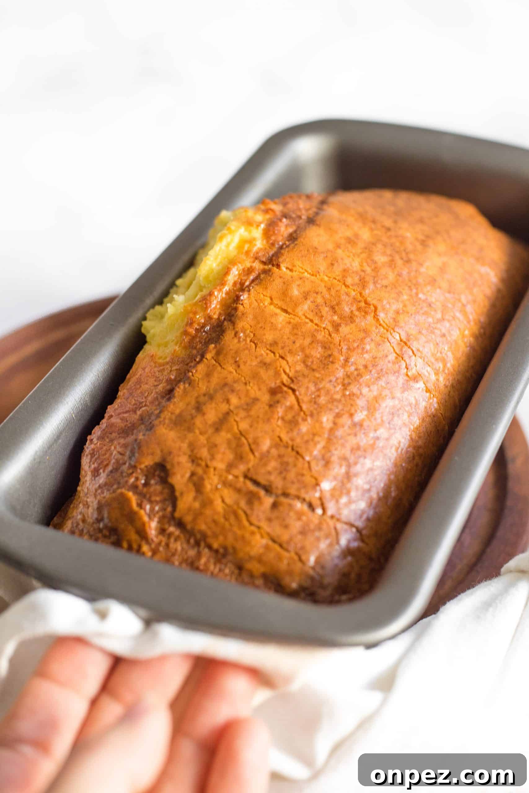 Holding a pan with freshly baked bread.