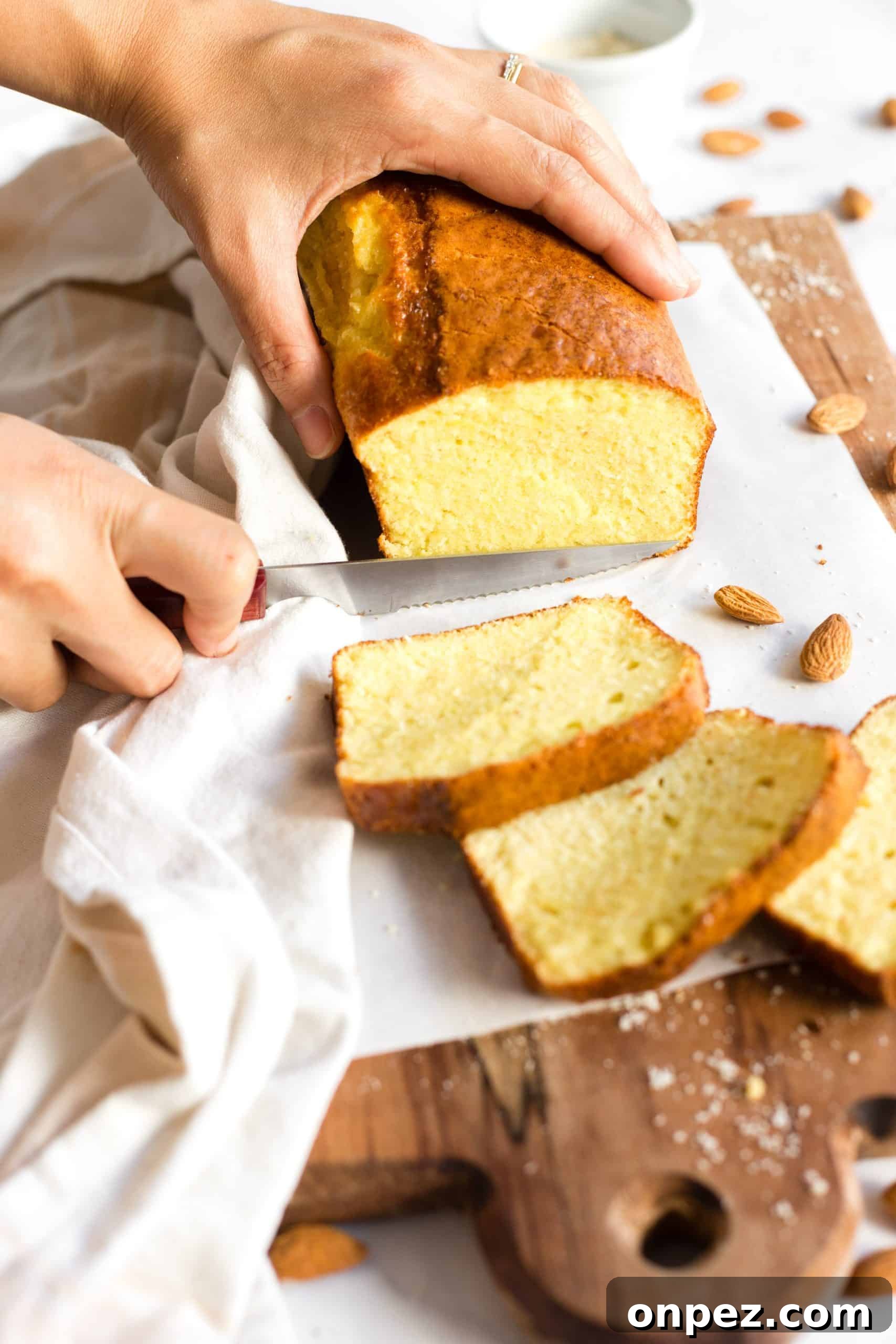 Slicing into a loaf of bread on a wooden board.