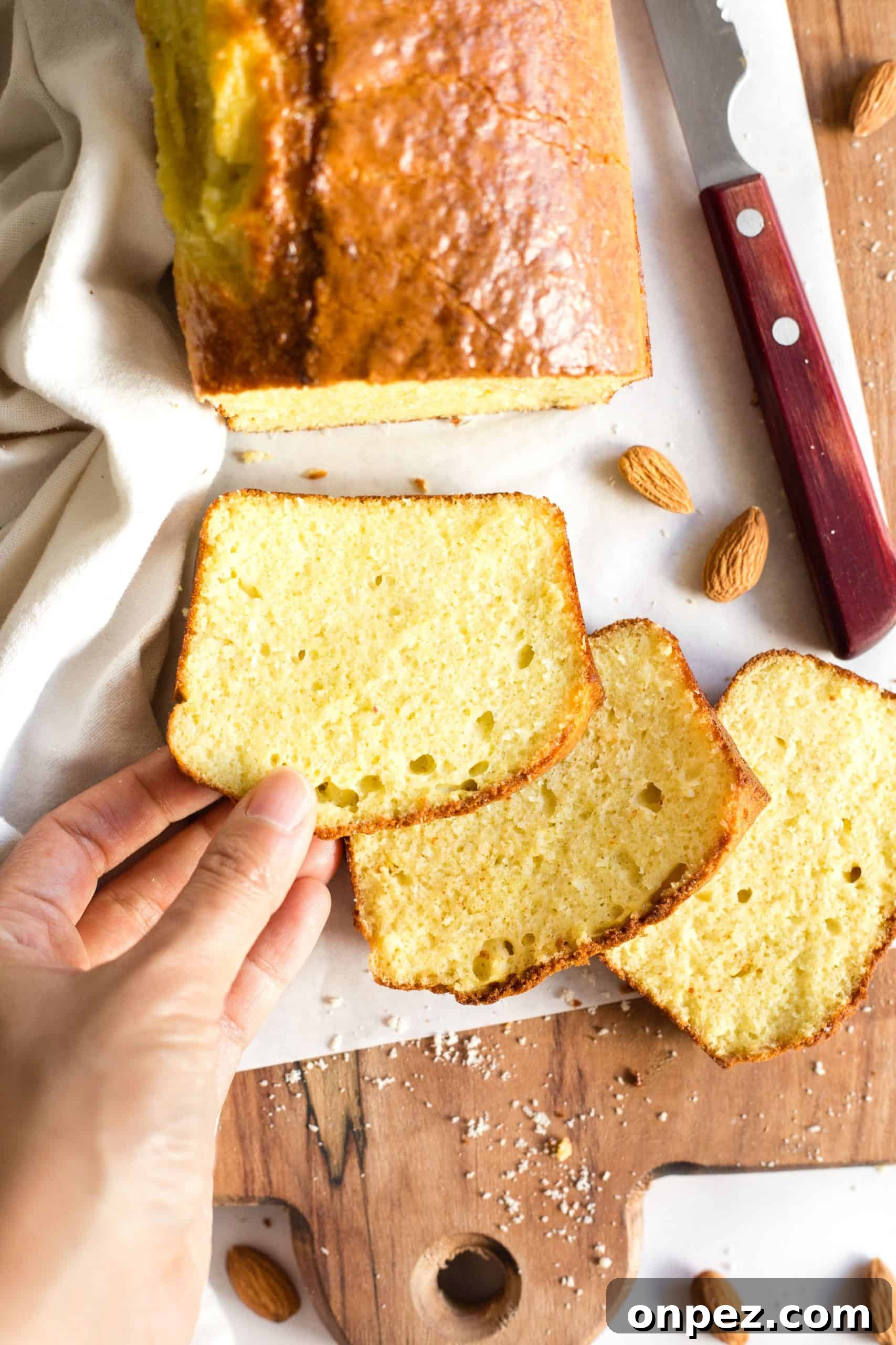 Hand holding a slice of gluten-free almond bread.