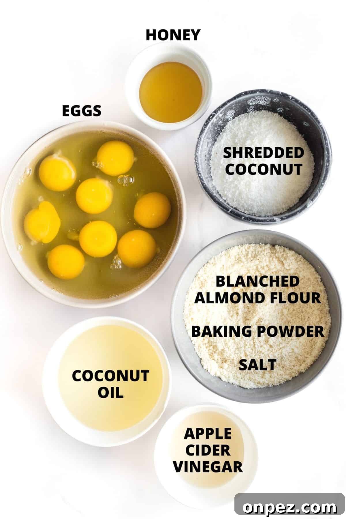 Labeled ingredients for almond flour bread recipe laid out on marble board.