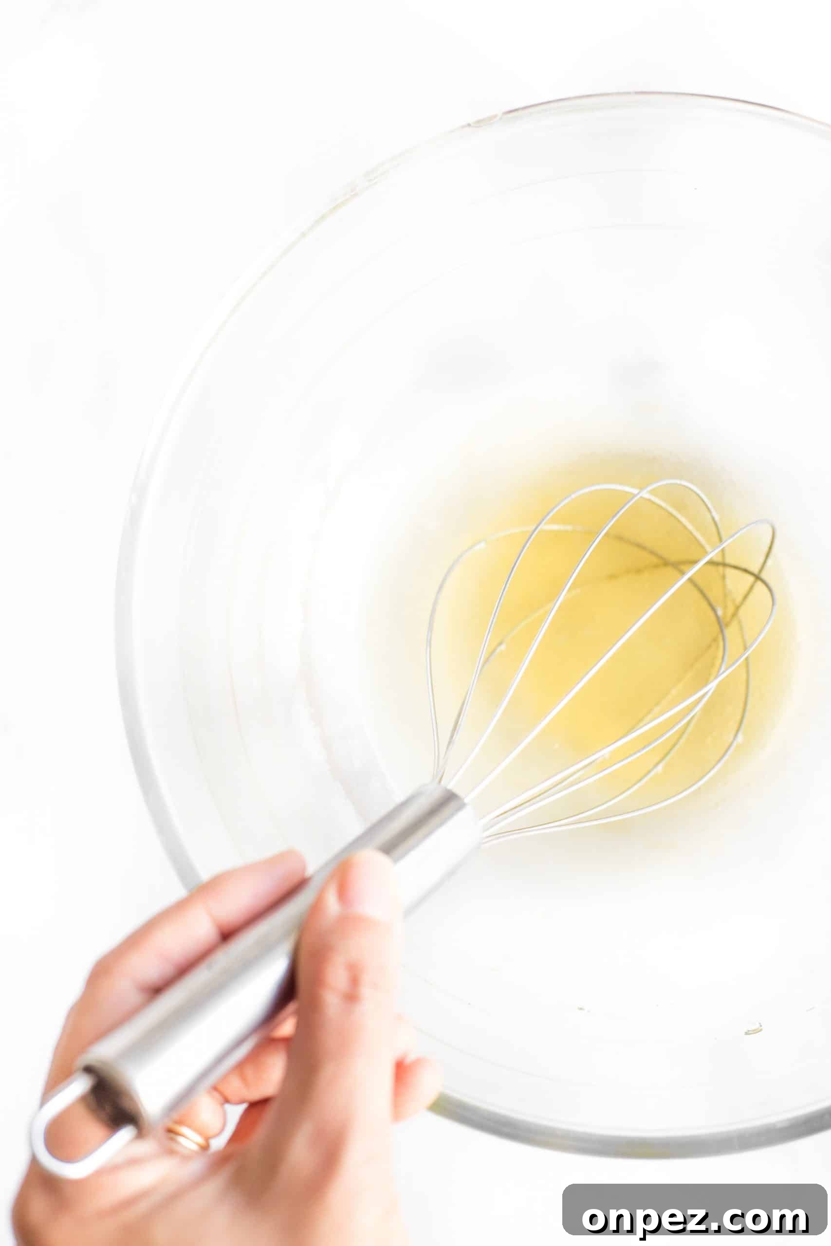 Whisking liquid in a glass bowl.