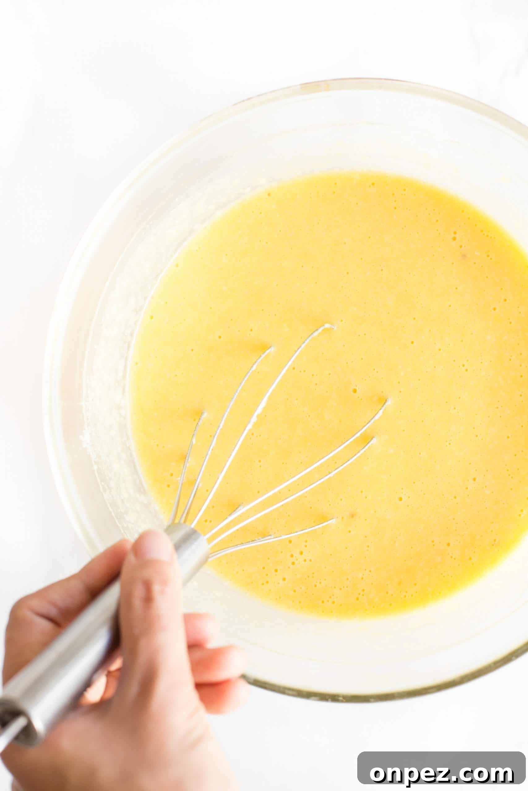 Hand whisking quick bread batter in a large bowl.