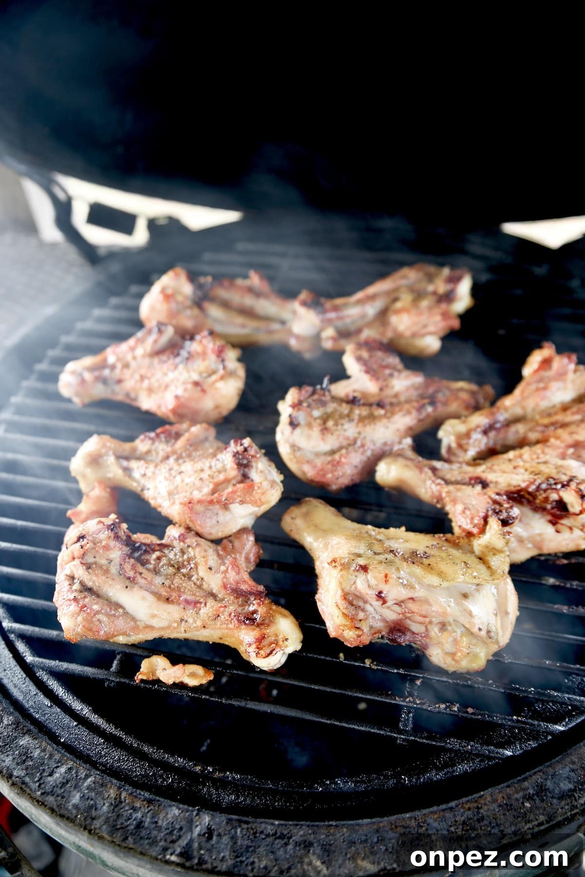 Grilling butterflied chicken drumsticks.