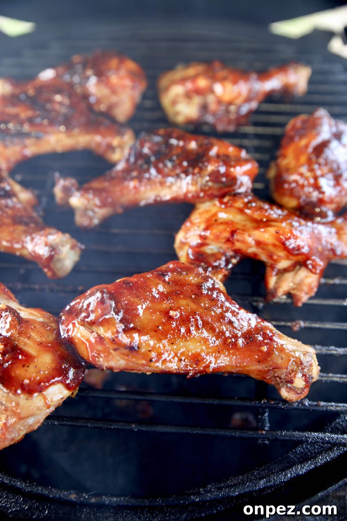BBQ butterflied chicken drumsticks on a grill.