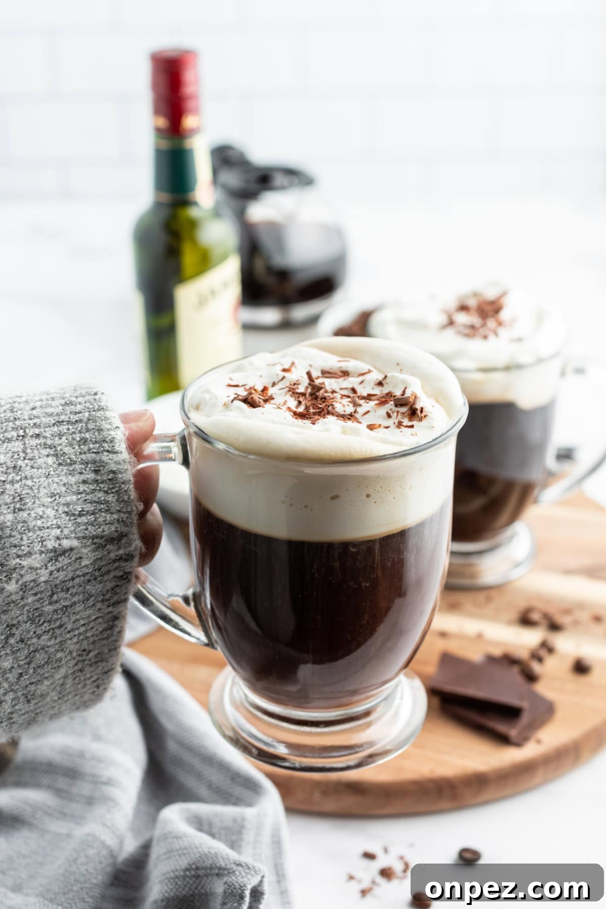 Irish Coffee hand holding cozy mug of irish coffee