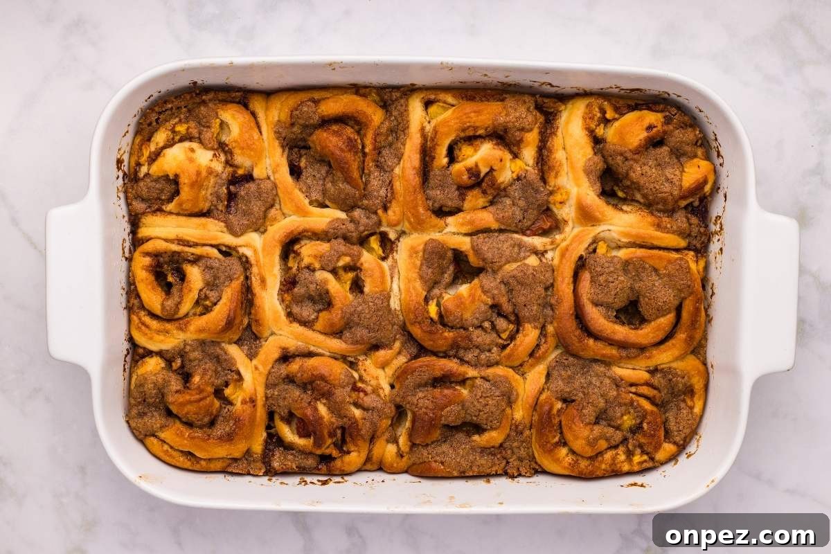 Baked cinnamon rolls in a white rectangular dish.