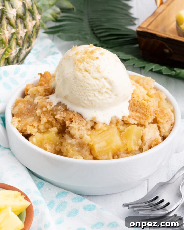 Quick Lemon Dump Cake Recipe 6 Pineapple dump cake in a white bowl with a scoop of ice cream.