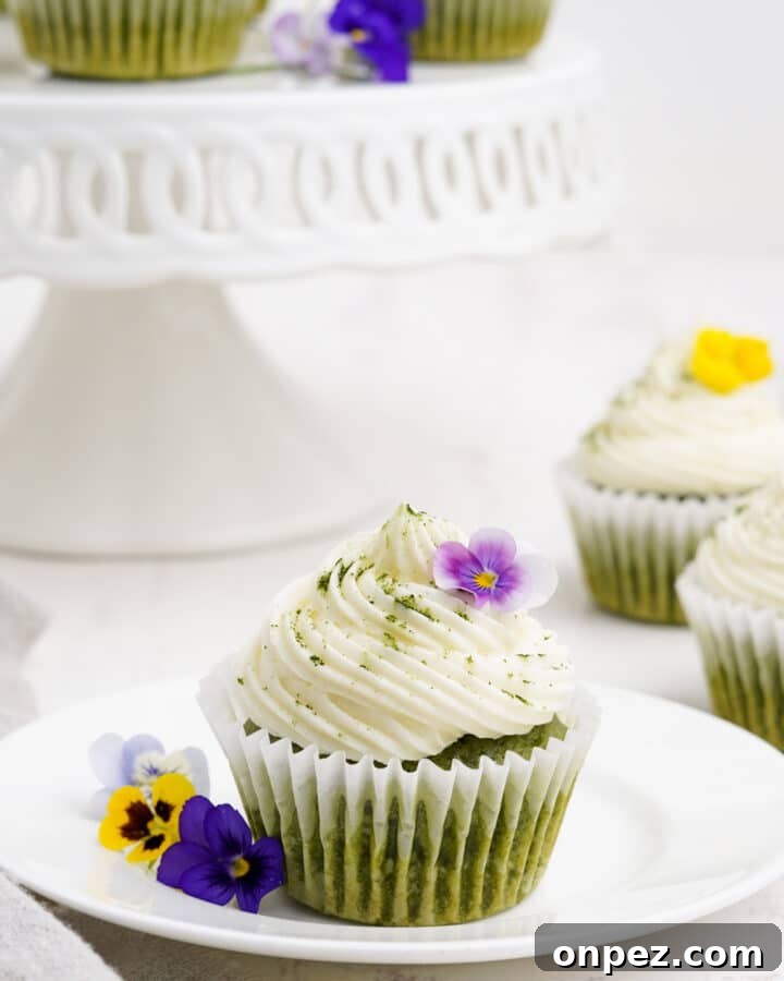 Quick Lemon Dump Cake Recipe 7 Matcha cupcake on a plate with flowers and more cupcakes in the background.