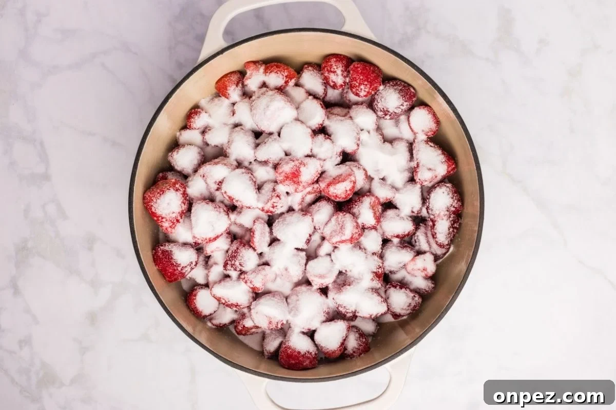 Homemade Strawberry Butter Canning Recipe and Tips 4 Sliced strawberries mixed with sugar in a large pot seen from above.