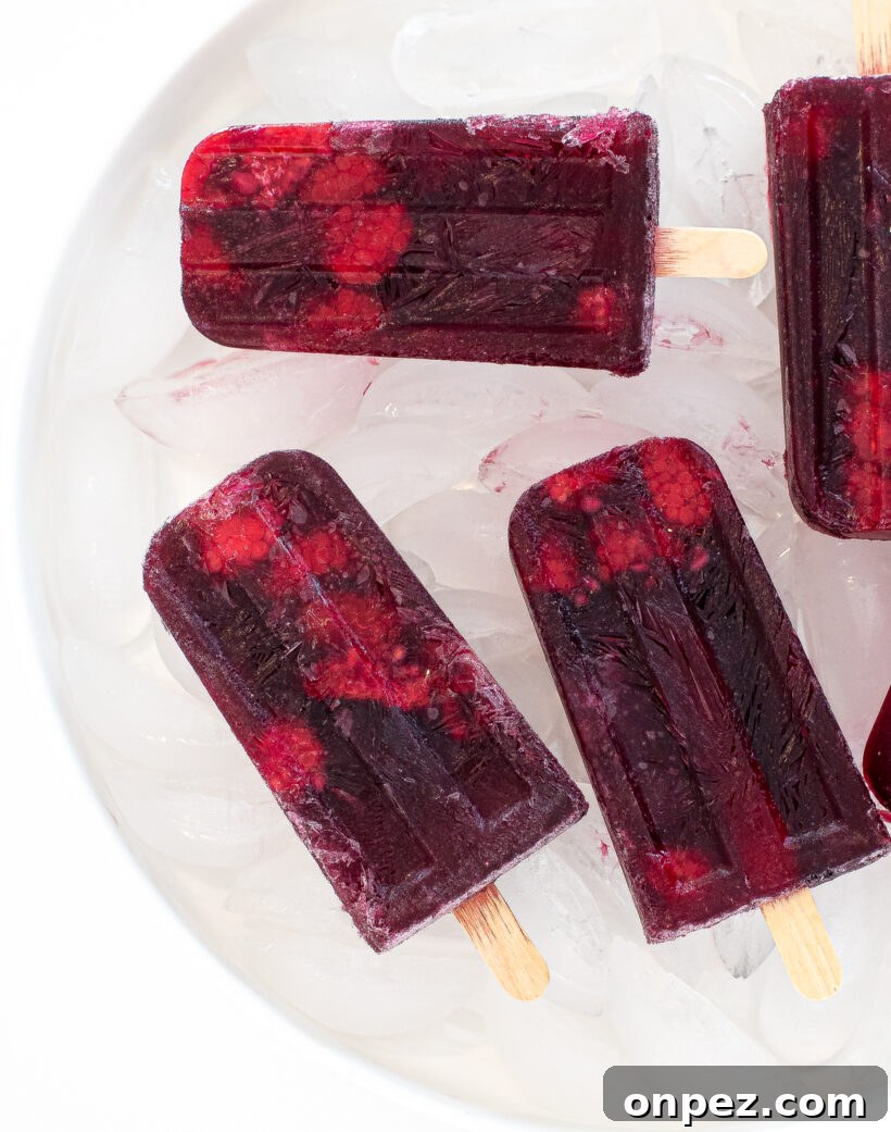 Sangria Popsicle Recipe: Refreshing Wine Pops for Summer 2 Sangria popsicles on a bed of ice in a white bowl.