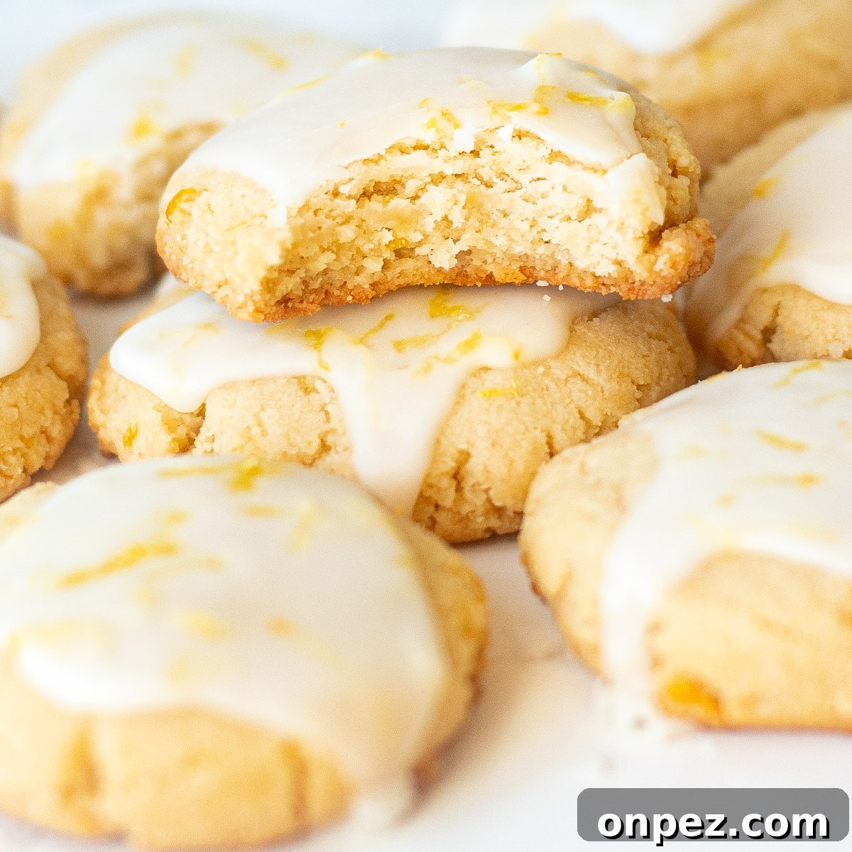 iced almond lemon cookies, one with a bite taken out