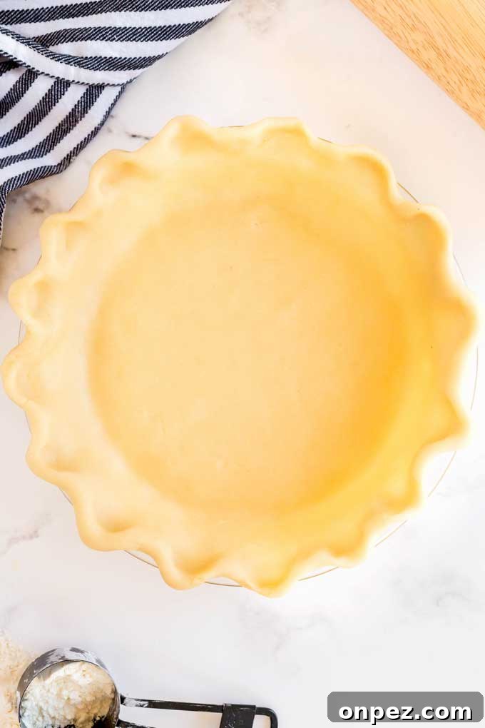 Perfect Homemade Pie Crust Recipe: Flaky and Foolproof 2 Unbaked pie crust on a pie plate, ready to be baked.