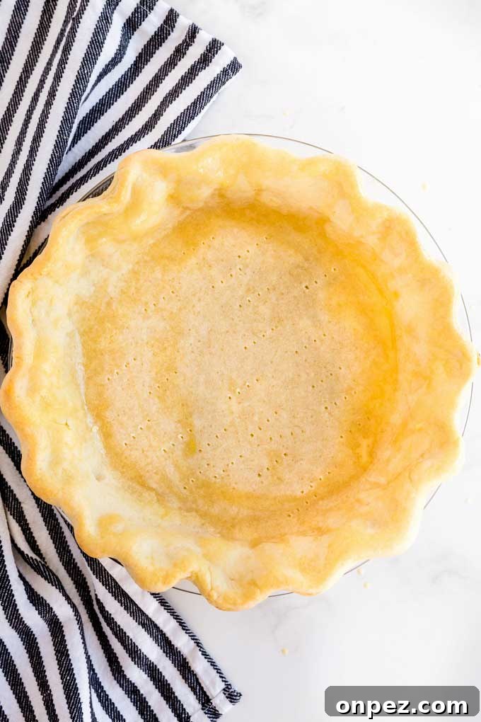 Perfect Homemade Pie Crust Recipe: Flaky and Foolproof 3 Golden brown baked pie crust on a white marble surface.