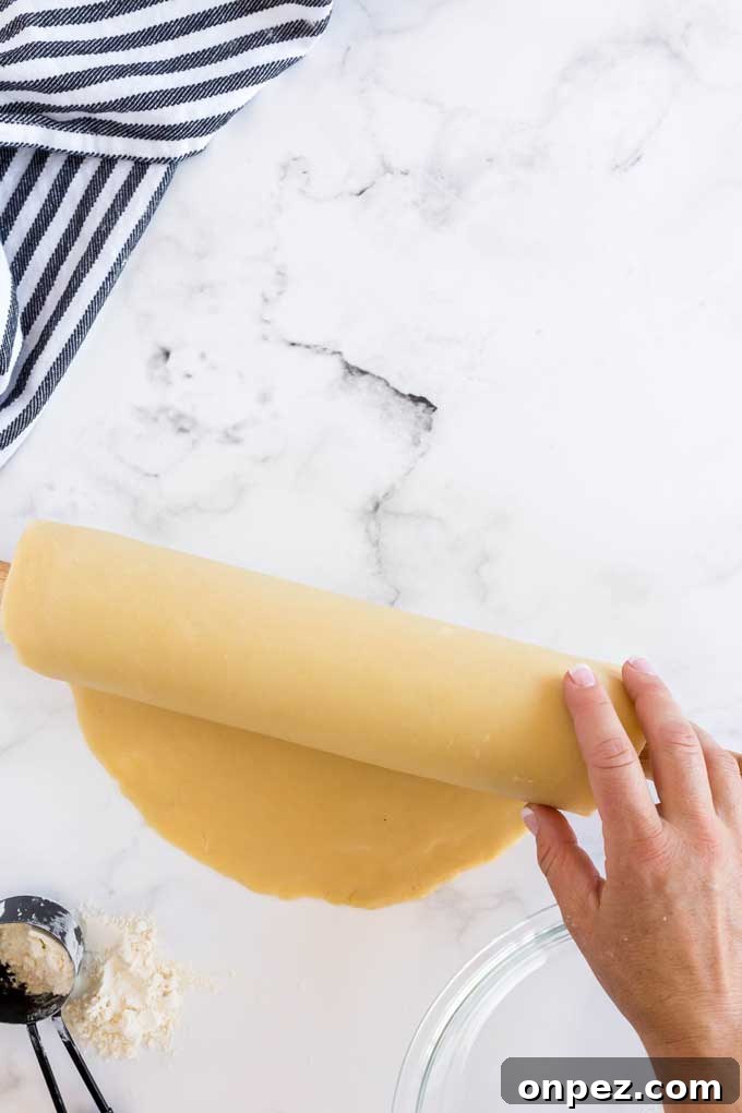 Perfect Homemade Pie Crust Recipe: Flaky and Foolproof 5 Rolling pie dough on a rolling pin to transfer it to a pie plate.