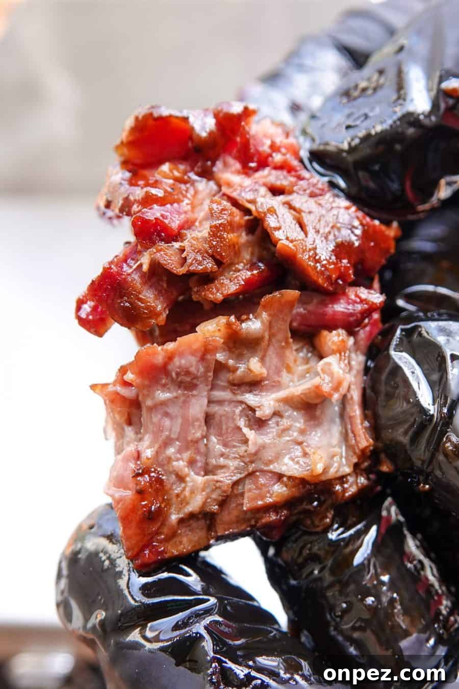 Budget Burnt Ends: Incredibly Tender Brisket Bites 2 Smoked burnt end being ripped in half with black gloves