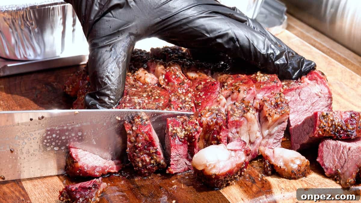 Budget Burnt Ends: Incredibly Tender Brisket Bites 7 Slicing smoked chuck roast into small pieces on cutting board for burnt ends