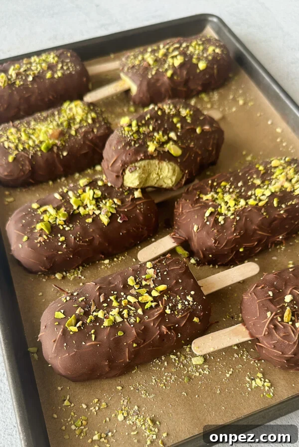 Pistachio ice cream bars on a baking sheet.