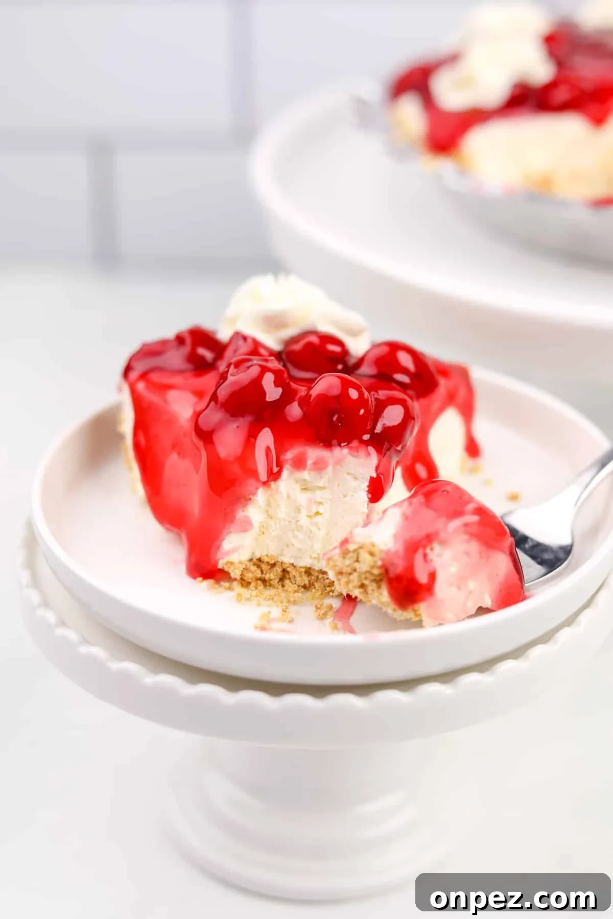 A slice of cherry no bake cheesecake with a fork on the side.