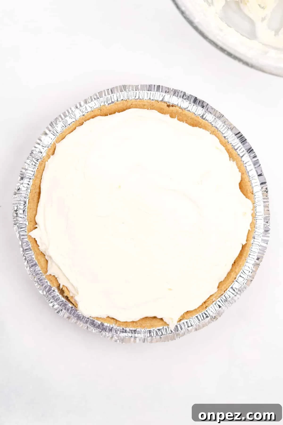 A premade graham cracker crust filled with cheesecake filling.