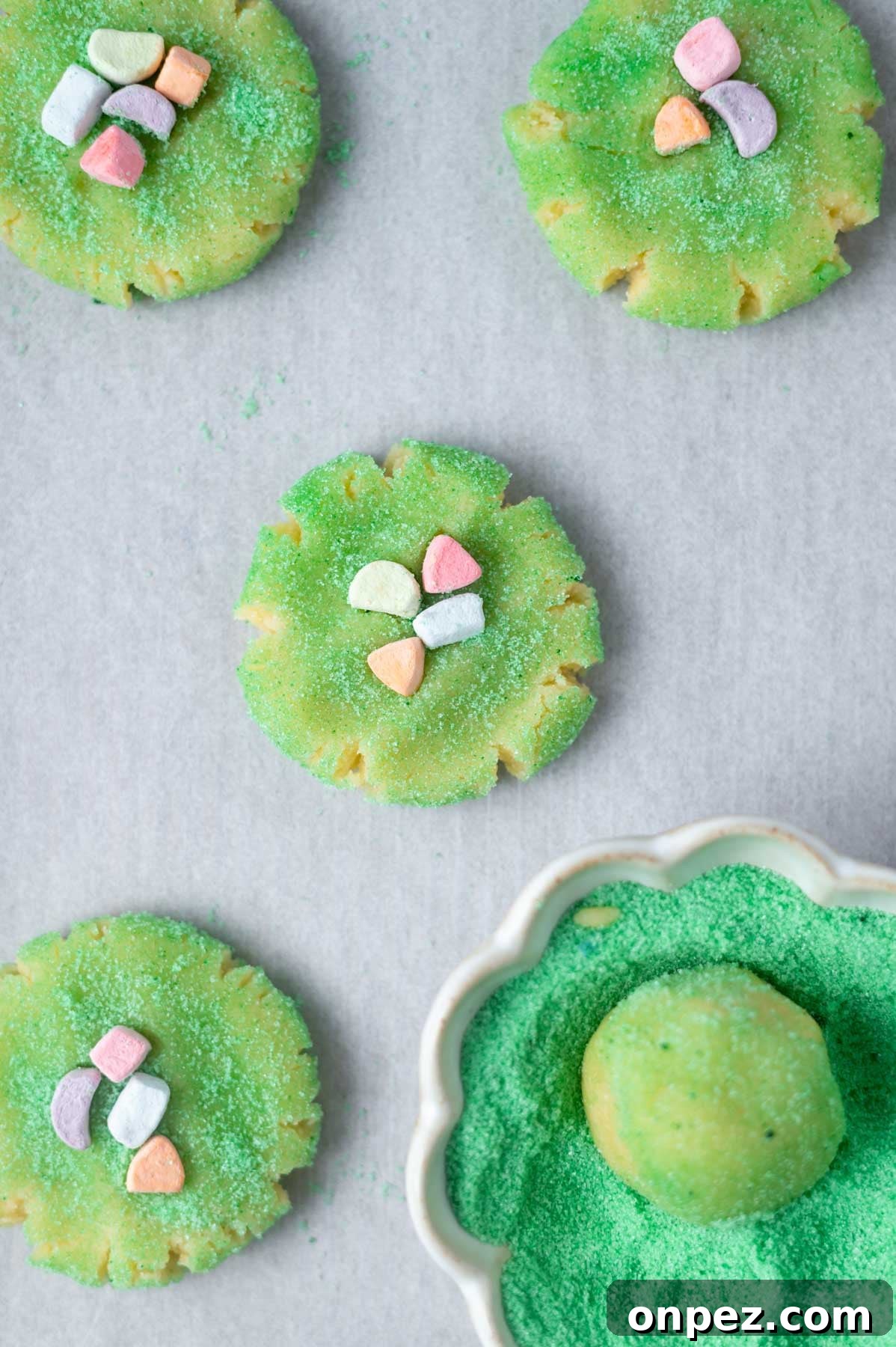 St Patricks Day Sugar Cookies with Festive Green Icing 8 cookies rolled in green sugar and topped with cereal marshmallows on a parchment lined baking pan