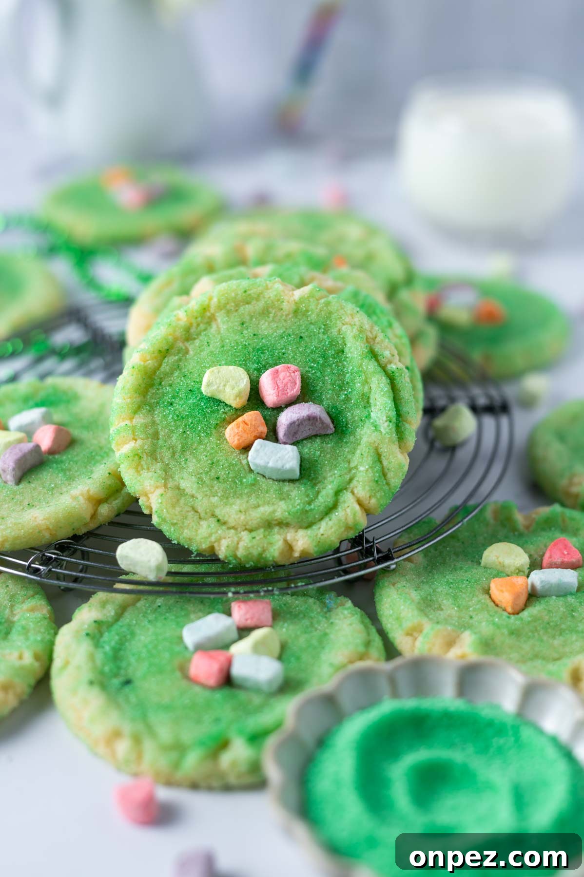 St Patricks Day Sugar Cookies with Festive Green Icing 9 cookies with colored cereal marshmallows for decoration piled on a cooling rack