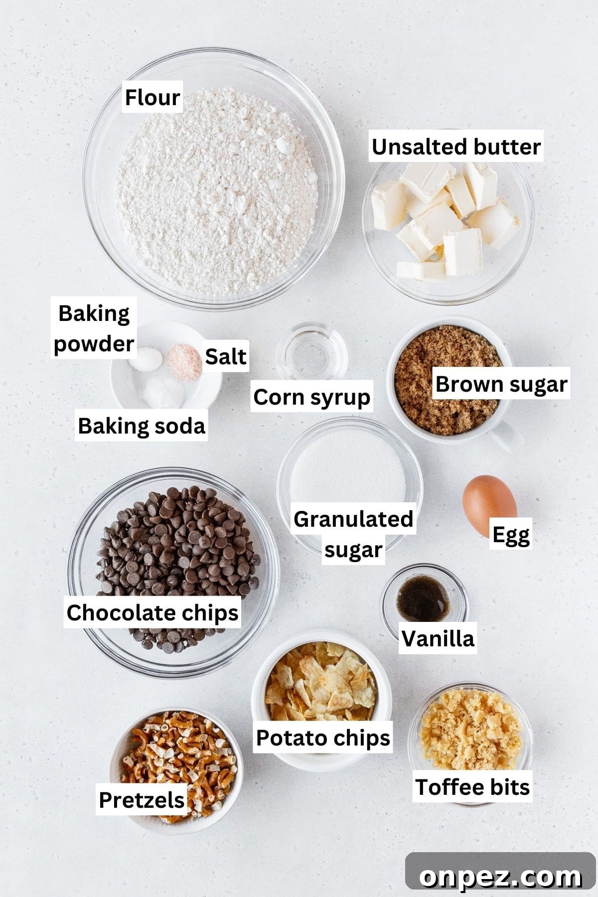 Kitchen sink cookie ingredients measured out into bowls on a white surface with text overlay.