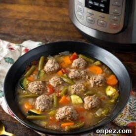 Pressure Cooker Albondigas Soup in black bowl in front of pressure cooker