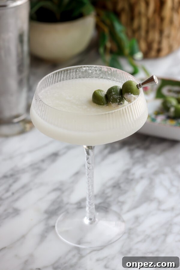 An easy quick vodka cocktail, Milky Dirty Martini pictured in a chilled glass with olives.