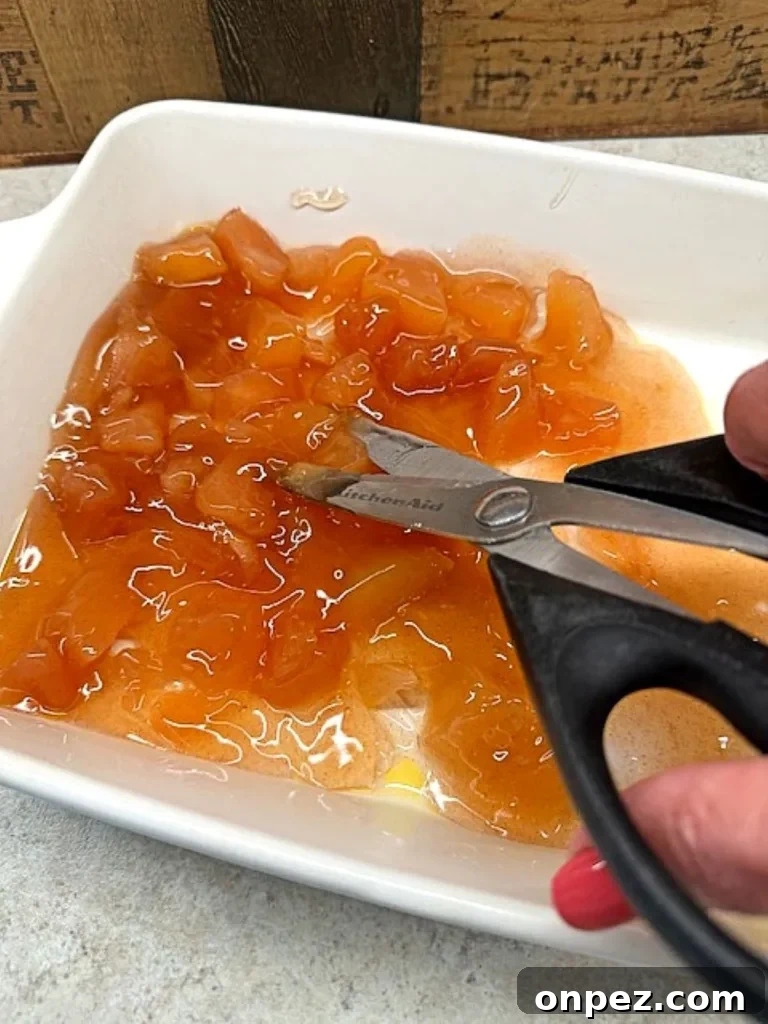 cut apple pie filling and cinnamon roll pieces in the pan