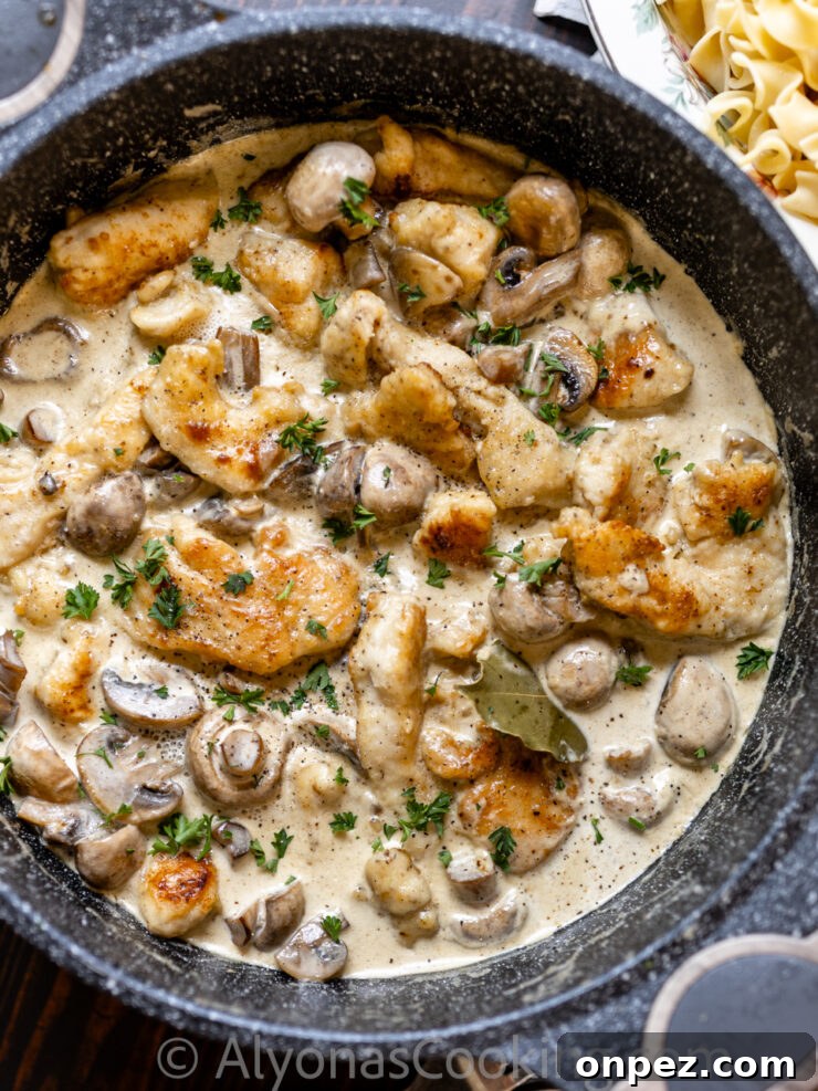 Smothered Chicken in Creamy Mushroom Sauce 2 image of smothered chicken with a cream gravy, and whole mushrooms