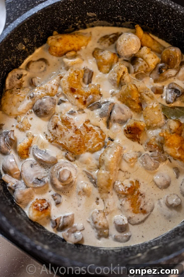 Smothered Chicken in Creamy Mushroom Sauce 5 image of smothered chicken with mushrooms in a pan