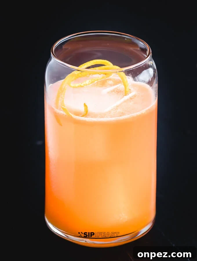A glass with the Italian Margarita, ice and orange peel.