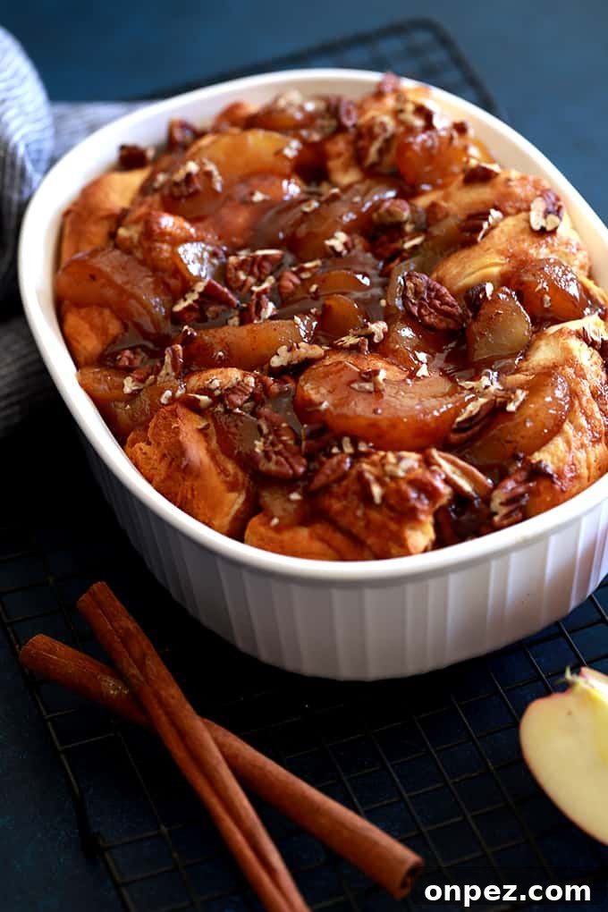 An Apple Pie Biscuit Casserole flanked by cinnamon sticks.
