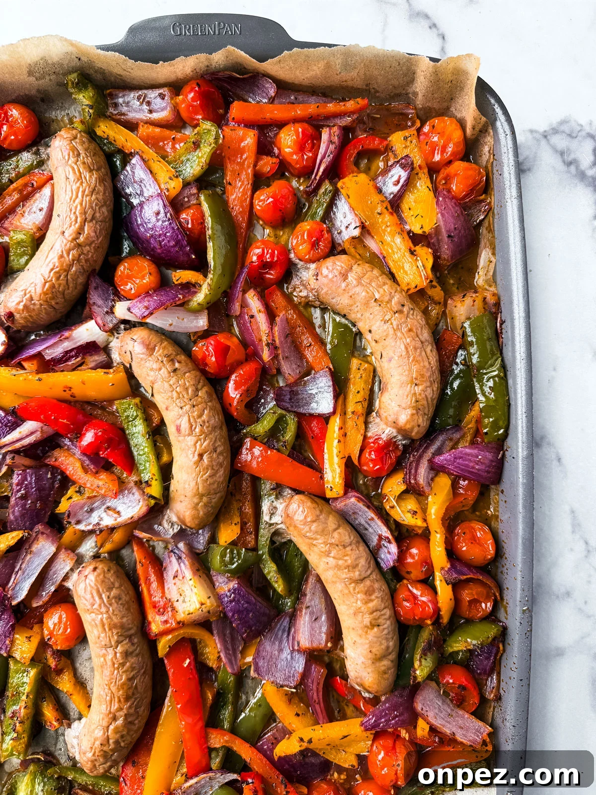 Sheet Pan Turkey Sausage with Roasted Peppers 2 Roasted turkey sausages on a sheet pan with vegetables.