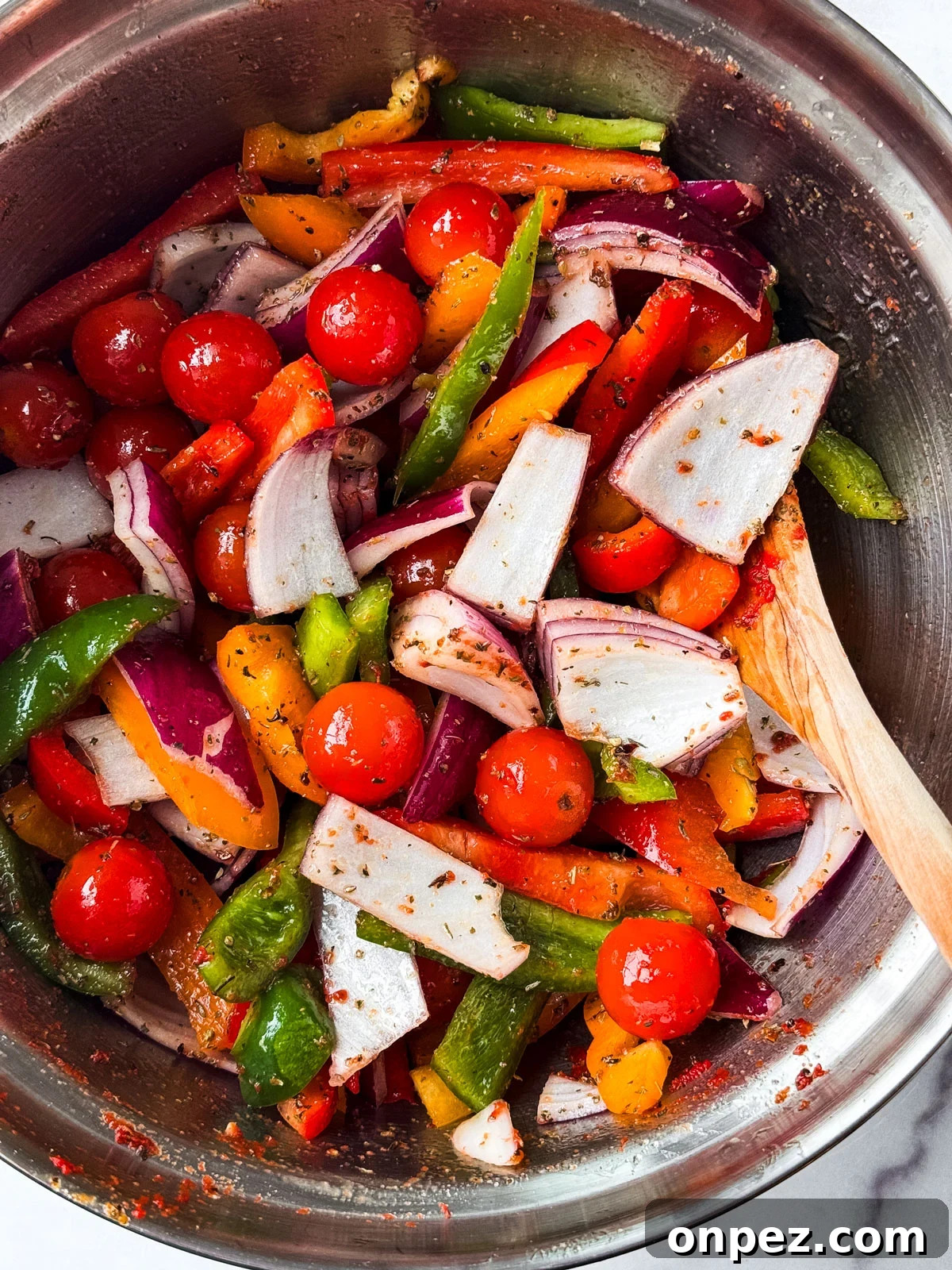 Sheet Pan Turkey Sausage with Roasted Peppers 4 Mixing bowl of seasoned vegetables.