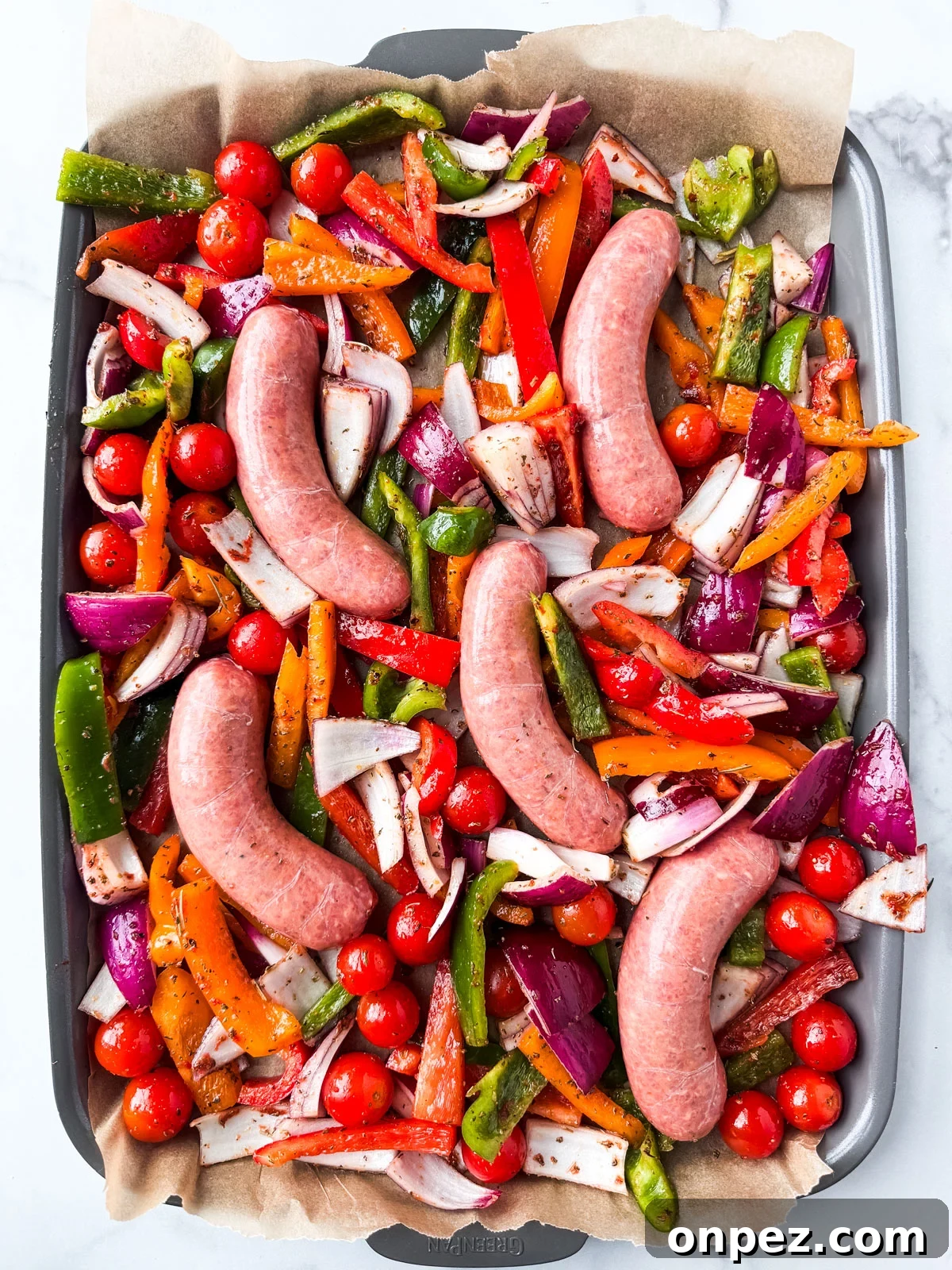 Sheet Pan Turkey Sausage with Roasted Peppers 5 Sheet pan of uncooked veggies and turkey sausage.