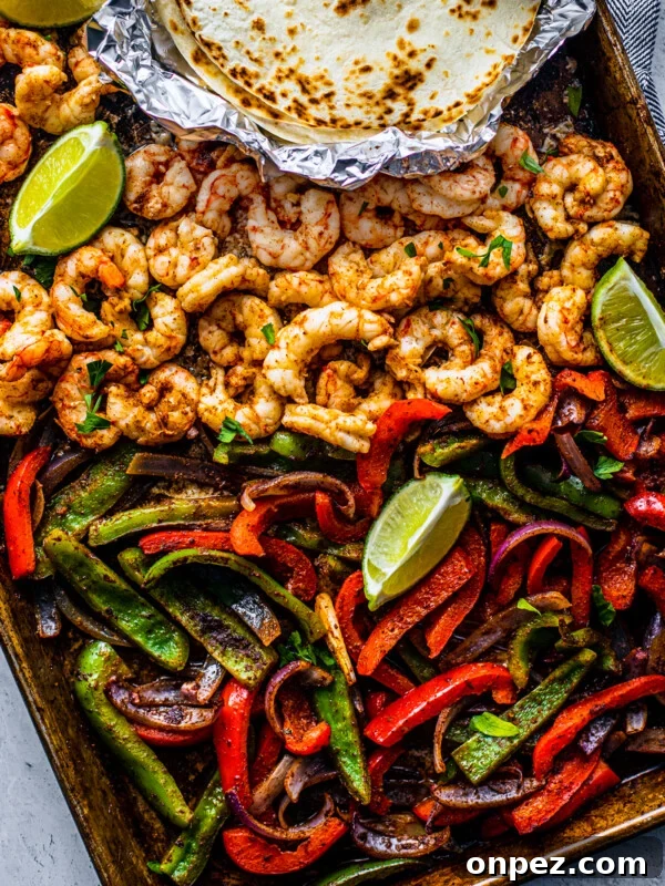 Sheet Pan Turkey Sausage with Roasted Peppers 10 Sheet pan covered with peppers, onions and shrimp with some lime wedges and soft shell tortillas on the side.