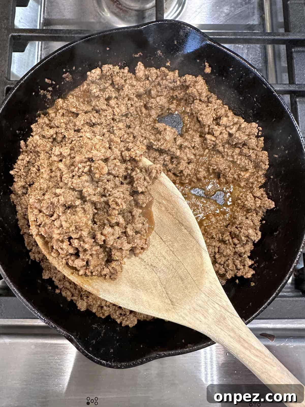 DIY Taco Seasoning Mix: Homemade Spice Blend 9 Cooked beef with taco seasoning in a skillet with a spoon.