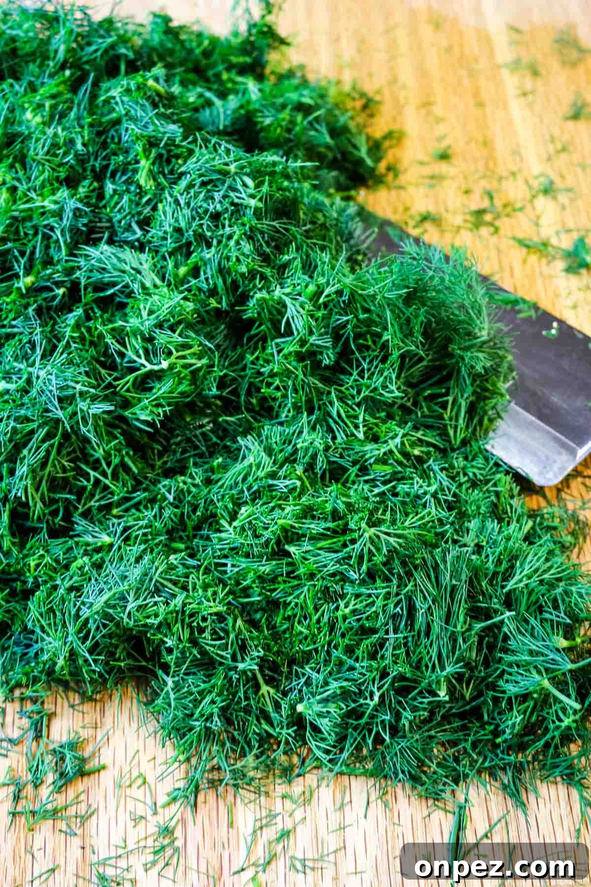 How to Chop Fresh Dill for Maximum Flavor and Yield 2 how to chop dill on cutting board and knife to the side.