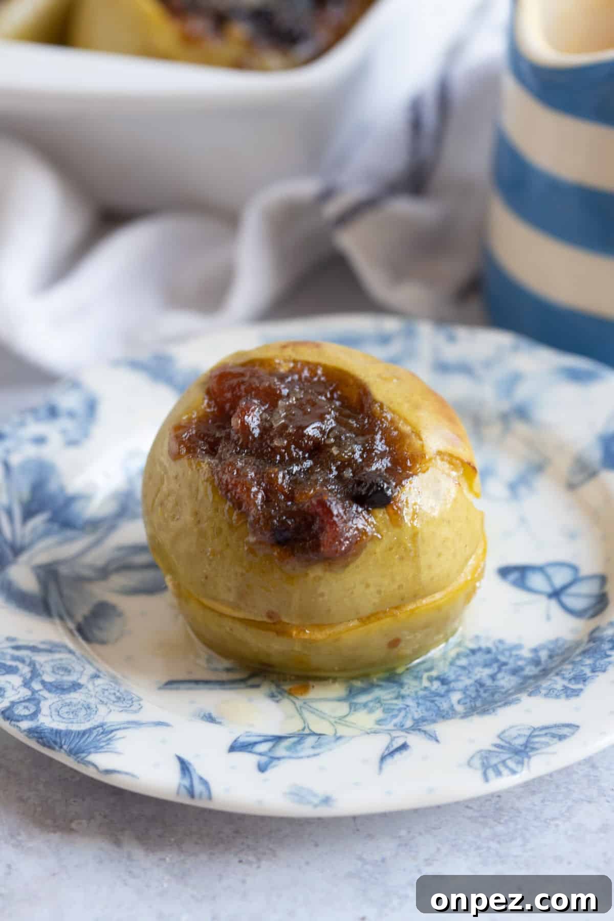 A baked apple with mincemeat on a dessert plate.