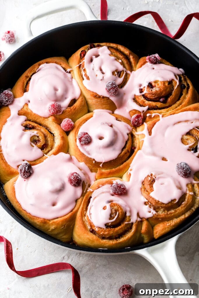 9 cranberry orange cinnamon rolls with cranberry glaze and sugared cranberries. 