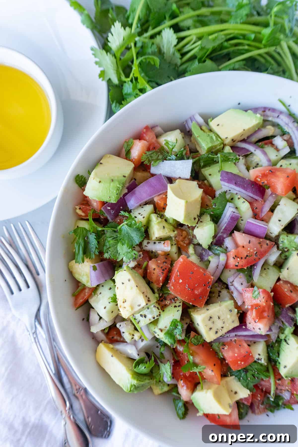This cucumber avocado salad is easy to make and perfect for summer! You will want to make this again and again! #avocado #easy #healthy #Mediterranean #atablefulofjoy #onion #simple #avocado #cucumber Cucumber Avocado Salad in bowl close up