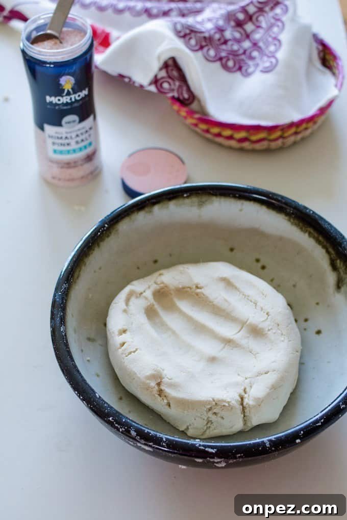 How to Make Authentic Corn Tortillas at Home 8 Fresh masa in a white ceramic bowl with a black rim on a white table.