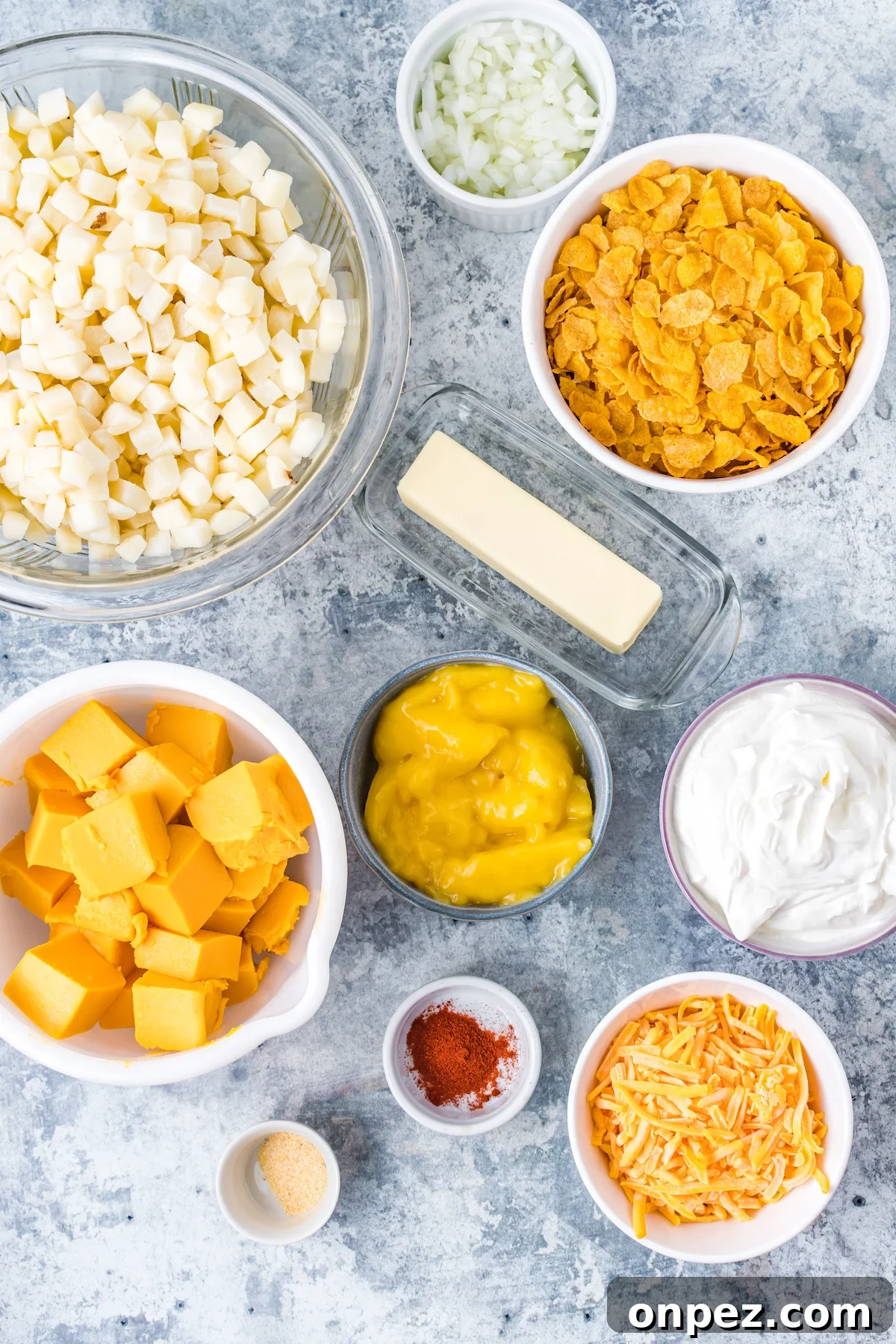 Classic Funeral Potatoes: Creamy Hashbrown Casserole Recipe 4 All the ingredients to make funeral potatoes in prep bowls on a countertop.